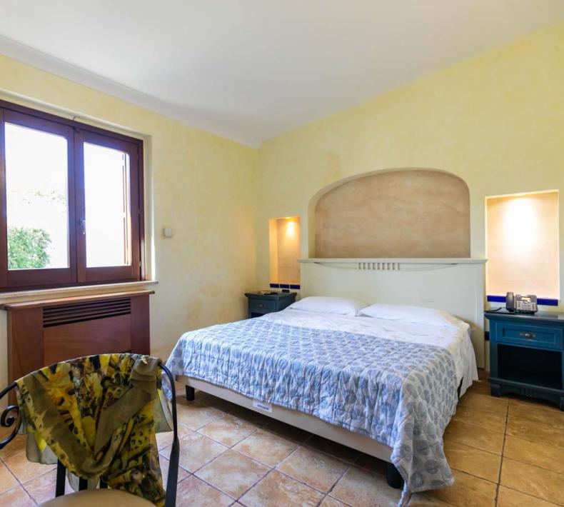 Bright bedroom with a double bed and large windows.
