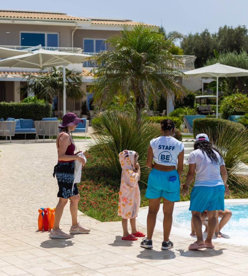 Family and staff near the pool at a resort.