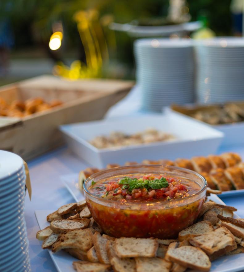 Buffet con piatti vari, crostini e salsa di pomodoro.