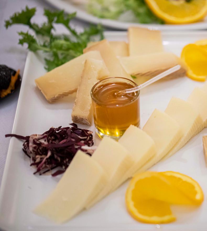 Käseplatte mit Honig, Orangen und Gemüse.